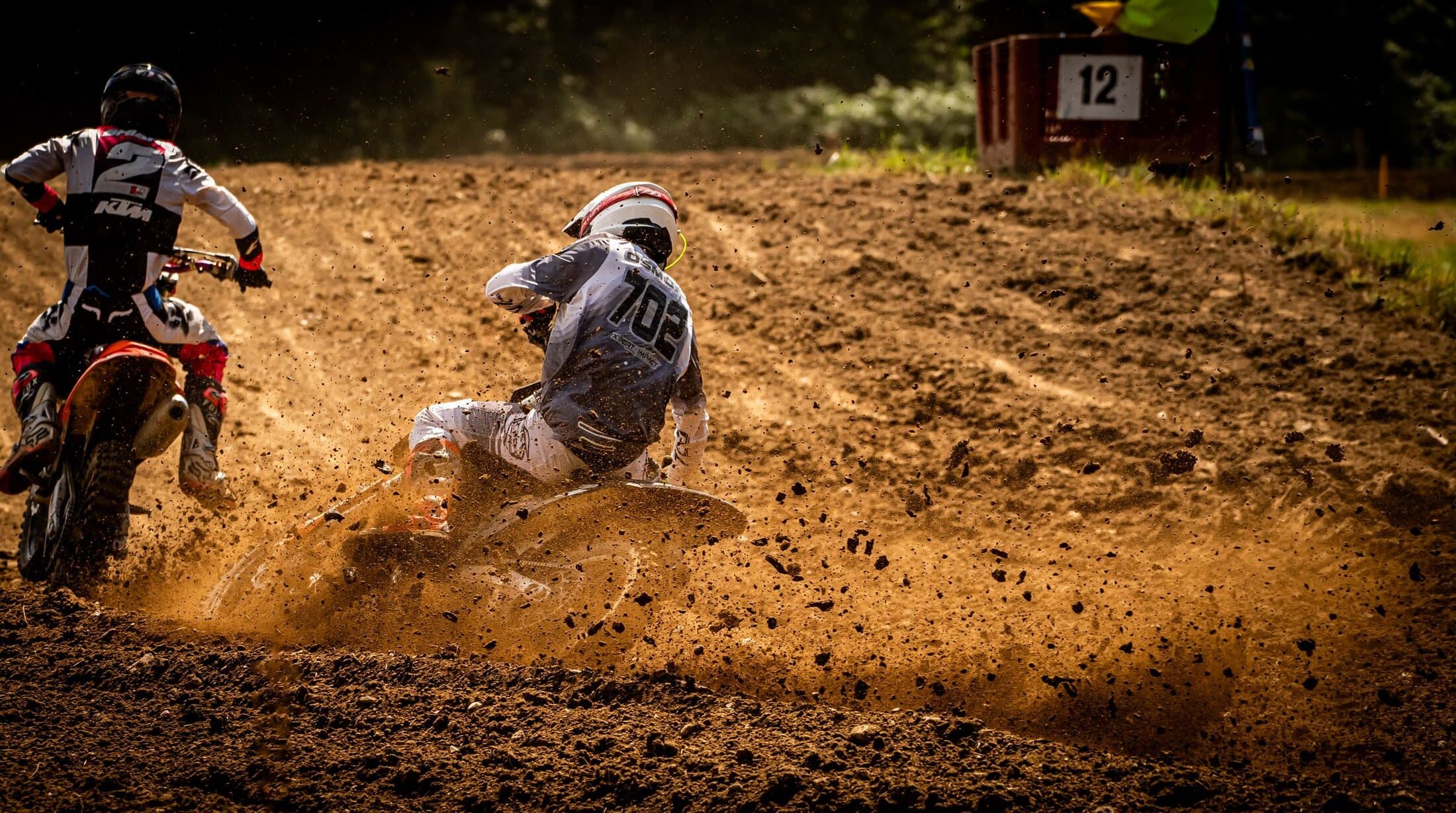 A rider throwing roost out of a rutted corner